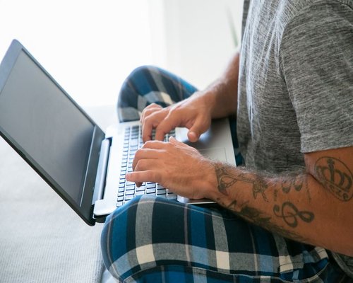 A person typing on a laptop with a comfortable posture