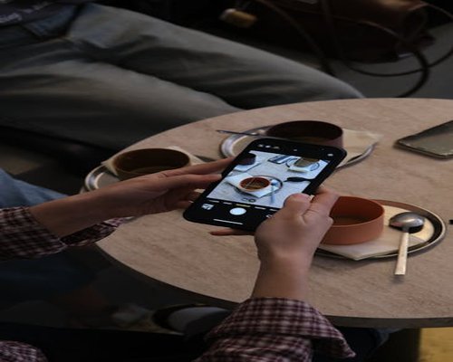 Hands holding a smartphone in an urban cafe